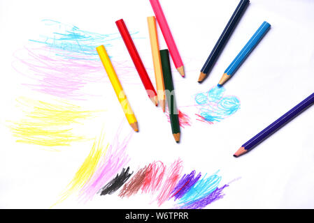 Colour pencils on white paper background paint education concept / wooden crayon multicolored drawings Stock Photo