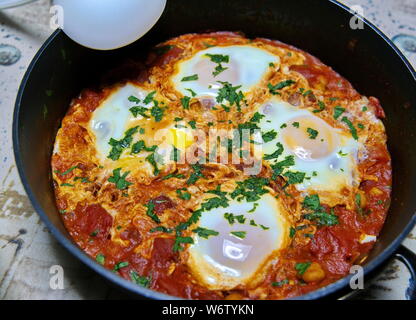 An African dish called Shakshuka is made up primarily of eggs, tomatos and other ingredients. Stock Photo