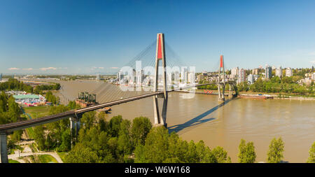 Aerial panoramic view of Skytrain Bridge over the Fraser River. Taken in Surrey, Greater Vancouver, British Columbia, Canada. Stock Photo
