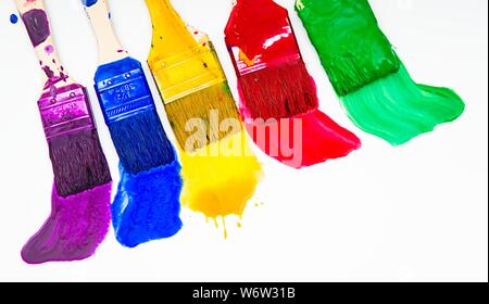 Paintbrushes dripping paint of various colors Stock Photo