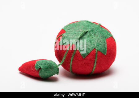 Pin Cushion without pins made out of red and green fabric isolated on white background Stock Photo
