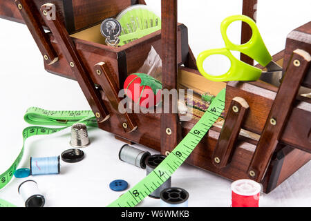 Vintage Wooden Sewing Box for storage of accessories like needles, utensils, thimble, yarn, pins, pin cushion.. Isolated against white background Stock Photo