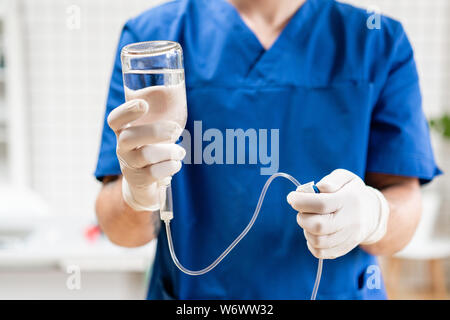 Medical treatment emergency concept. Doctor holding drip and adjust infusion pump set iv fluid. Intravenous drop saline drip for seriously patient in Stock Photo