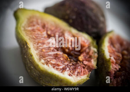 A close up of three figs on a plate Stock Photo