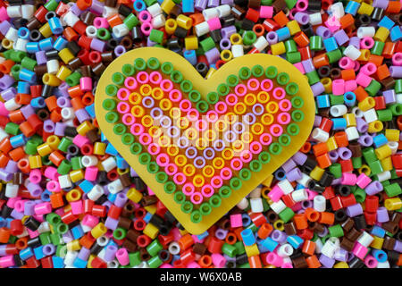 background with colorful beads, macro wallpaper and hearts made from beads Stock Photo