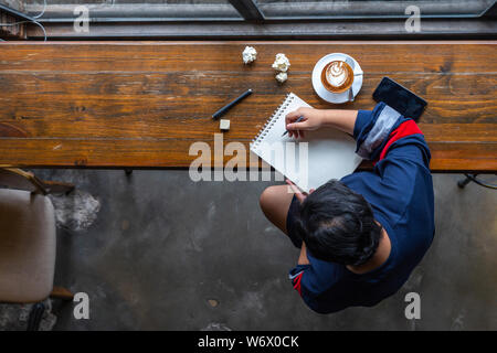 High angle view of Asian student drawing on sketchbook Stock Photo