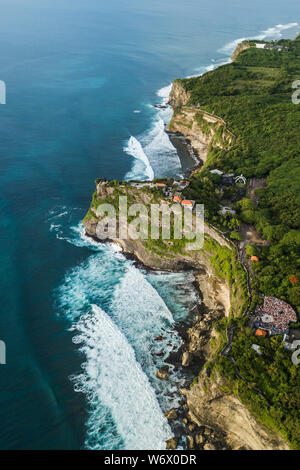 Aerial view of Uluwatu temple in Bali, Indonesia. Beautiful balinese landscape with huge waves and rocky ocean shore Stock Photo