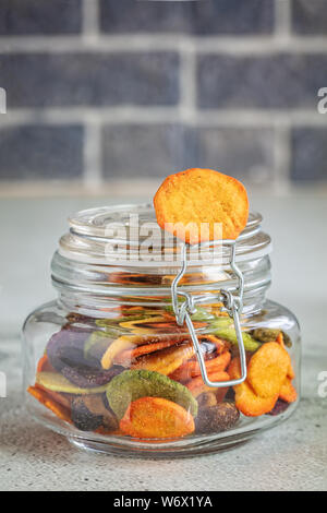 Colourful mix vegetable chips in glass jar, vertical composition Stock Photo