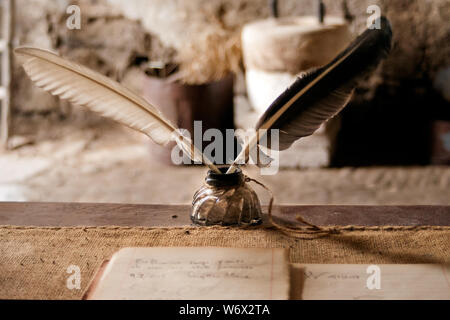 vintage writing table with pens and ink. Stock Photo