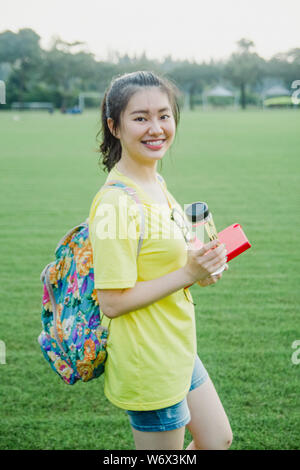 Young girl student having fun on grass field in the afternoon in campus Stock Photo