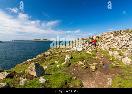 The rock strewn approach to St Davids Head with Ramsay Island beyond, Pembrokeshire Coast National Park, Wales, UK Stock Photo