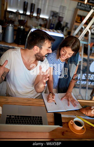 happy cafe managers working on laptop in cafe. Stock Photo
