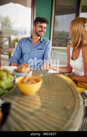 Handsome cheerful man with woman sitting at the table Stock Photo