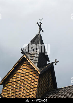 Heddal Stave church from the medieval period, a prime example of Norwegian wooden architecture and a tourist attraction, steeple, wooden tiles, cross Stock Photo