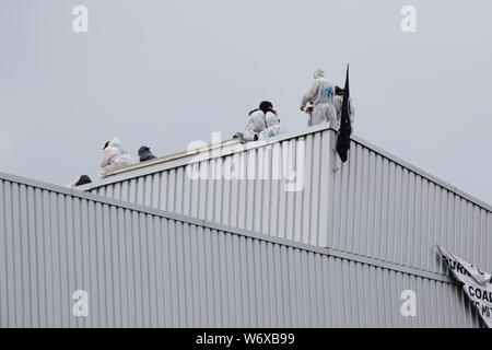 Mannheim, Germany. 3rd August 2019. Activists sit on top of the occupied large coal conveyor belt. Activists from the Ende Gelande organisation have occupied the coal conveyor belt on the large coal power plant in Mannheim. They also block the main entrance of the plant, calling for an end to the use of coal in energy production and the use of renewable energy sources. Stock Photo