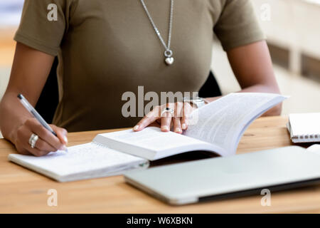 Close up african female hands holding pen make notes Stock Photo