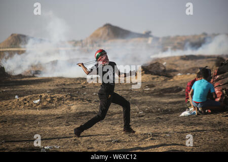 A Palestinian demonstrator seen throwing stones using a slingshot during the clashes.At least 51 Palestinians were injured on Friday afternoon in the weekly anti-Israel protest in the eastern Gaza Strip close to the border with Israel. Stock Photo