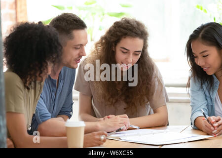 Different ethnicity businesspeople or students working together on project Stock Photo