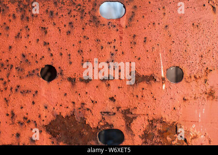 Old weathered rusty iron plank surface with holes closeup as grunge background Stock Photo
