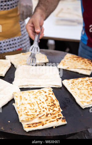 Person who bakes traditional Turkish gozleme, specifically Turkish cake in street food Stock Photo