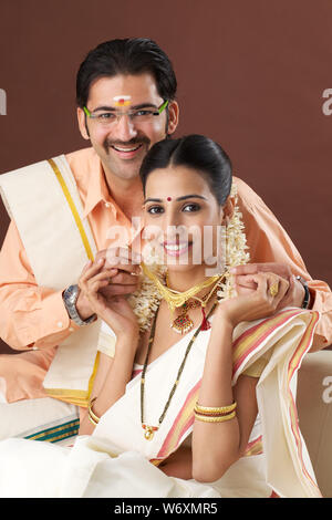 Indian couple holding gold jewelry, ornaments - Asset or Gold Loan