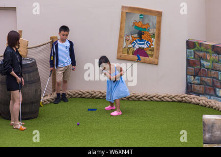 Bournemouth, Dorset UK. 3rd Aug 2019. Children and families enjoy the newly opened smuggler themed Adventure Golf Course, Smugglers Cove Adventure Golf, at Pier Approach. They wait excitedly to try out the new course and find out more about the smuggler theme on the first weekend following the official opening of the mini golf course on Wednesday 31st July. The use of the prime location on the seafront was controversial among locals with different ideas being proposed. Family playing mini golf minigolf miniature golf adventure golf putt putt. Credit: Carolyn Jenkins/Alamy Live News Stock Photo