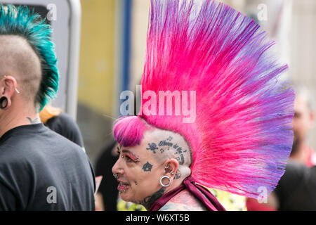 Woman with tattooed head and large Dyed mohican hairstyle & liberty spikes in Blackpool, Lancashire, UK. August 2019. The fabulous Punk Rebellion festival returns to the Winter Gardens in Blackpool for a weekend of live punk rock music.  The Rebellion Festival, formerly Holidays in the Sun and the Wasted Festival is a British punk rock festival first held in 1996.  This open to all event draws thousands of overseas visitors to see all their favourite punk musicians in one place.  Credit: Cernan Elias/Alamy Live News Stock Photo