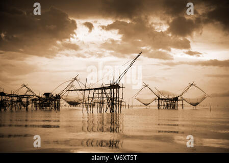 Old photo in sepia warm two tone vintage style, landscapes of Songkhla Lake and fishing square dip net is a local fishing tool rural lifestyle at Pakp Stock Photo