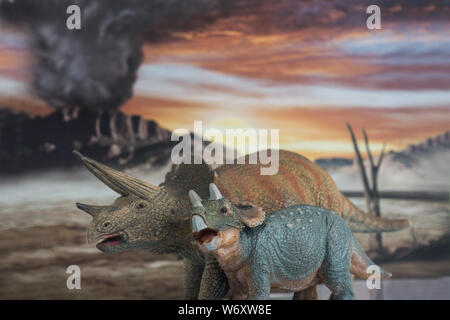 Family of triceratops with jurassic land into background. Mother and son with love. Stock Photo