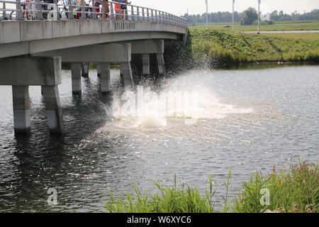 children jumping from a bridge during hot summer in the Netherlands Stock Photo