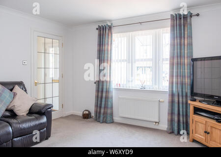 Two Walled View of Modern Lounge in Scottish Housing Developement with Decorated Walls french door and white windows Stock Photo