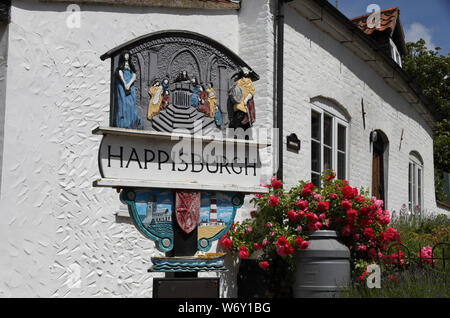 Painted village sign of attractive and historical Happisburgh, Norfolk, England in summer, a town under threat of coastal erosion Stock Photo