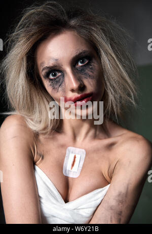 Strange crazy girl. Insane sad young woman (freak) with messy make-up. Portrait of the madman (mental sick) Stock Photo
