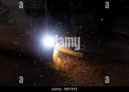 Operator welding steel construction. Industrial worker during welding works Stock Photo