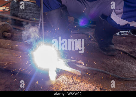 Operator welding steel construction. Industrial worker during welding works Stock Photo