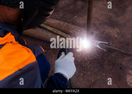 Operator welding steel construction. Industrial worker during welding works Stock Photo