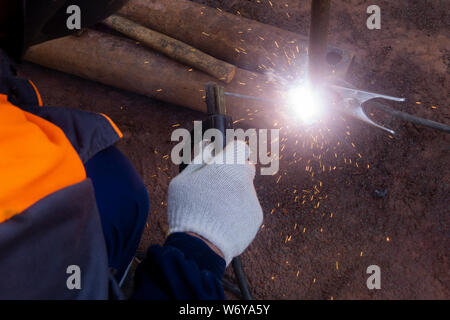 Operator welding steel construction. Industrial worker during welding works Stock Photo