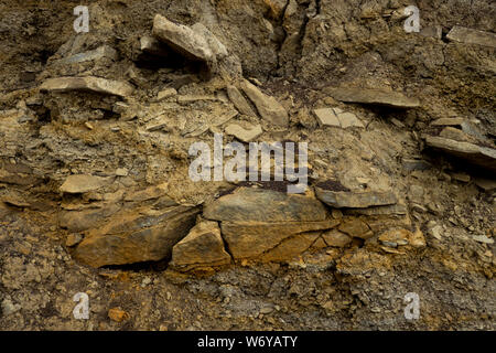 Soil cut-sandstone, stones, clay, sand structure and layers. slice of sand with layers of different structures. Stock Photo
