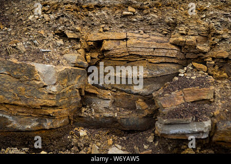 Soil cut-sandstone, stones, clay, sand structure and layers. slice of sand with layers of different structures. Stock Photo