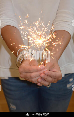 CELEBRATION!!: A woman holds a sparkler in her hand.