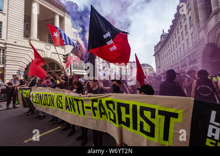 London, UK. 3rd August 2019. 'London is Anti-Fascist' banner at the front of the march in London to stop the racist 'Free Tommy' protesters marching. They say Tommy Robinson, in prison for deliberate contempt of court, is part of a far-right movement spreading violence across the world, whipping up hatred against Muslims and refugees. The Anti-fascists set off up Regent St and the Anti-racists joined behind them. Police stopped them close to Oxford Circus, but they went through side streets to get close to the 'Free Tommy' event before being stopped again. Peter Marshall Alamy Live News Stock Photo