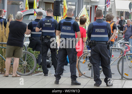 Landau, Germany. 3rd August 2019. Police officers watch the counter protest. Around 80 people from right-wing organisations protested in the city of Landau in Palatinate against the German government and migrants. They also adopted the yellow vests from the French yellow vest protest movement. The place of the protest was chosen because of the 2017 stabbing attack in the nearby city of Kandel, in which a 15 year old girl was killed by an asylum seeker. They were confronted by several hundred anti-fascist counter-protesters from different political parties and organisations. Stock Photo