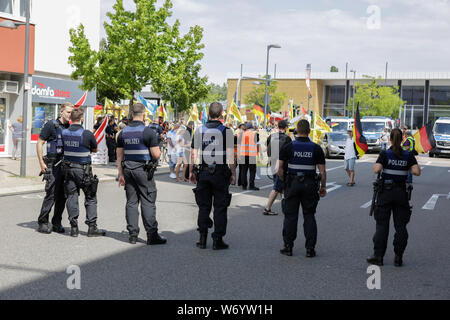 Landau, Germany. 3rd August 2019. Police officers watch the counter protest. Around 80 people from right-wing organisations protested in the city of Landau in Palatinate against the German government and migrants. They also adopted the yellow vests from the French yellow vest protest movement. The place of the protest was chosen because of the 2017 stabbing attack in the nearby city of Kandel, in which a 15 year old girl was killed by an asylum seeker. They were confronted by several hundred anti-fascist counter-protesters from different political parties and organisations. Stock Photo