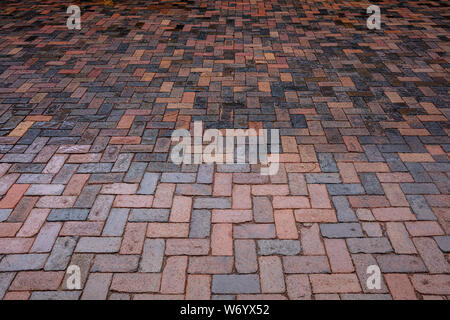 Cobblestone street background. Brown red color blocks texture outdoors, wet after the rain, high angle view Stock Photo