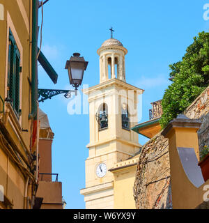 Old narrow street in Boccadasse district in Genoa and bell tower of Church of St. Anthony of Boccadasse, Italy Stock Photo