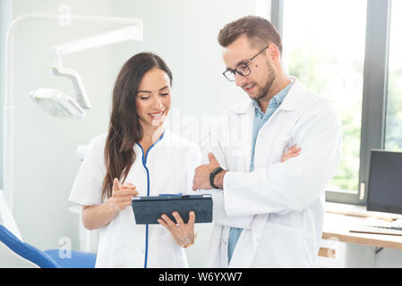 Medical workers working together in office. Female doctor holding digital tablet. Stock Photo