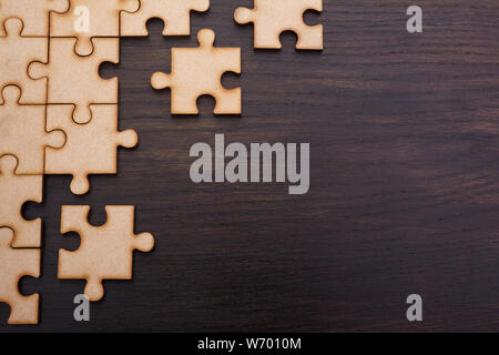 Incomplete jigsaw puzzles on dark wooden background Stock Photo
