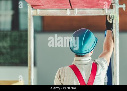 Construction Workers Safety on a Scaffolding. Working on Height Industrial Theme. Stock Photo