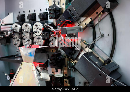 Springs making on the automatic spring coiling CNC machine. Stock Photo