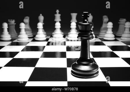 A chess black king single alone against white army concept strategy game one selective focus